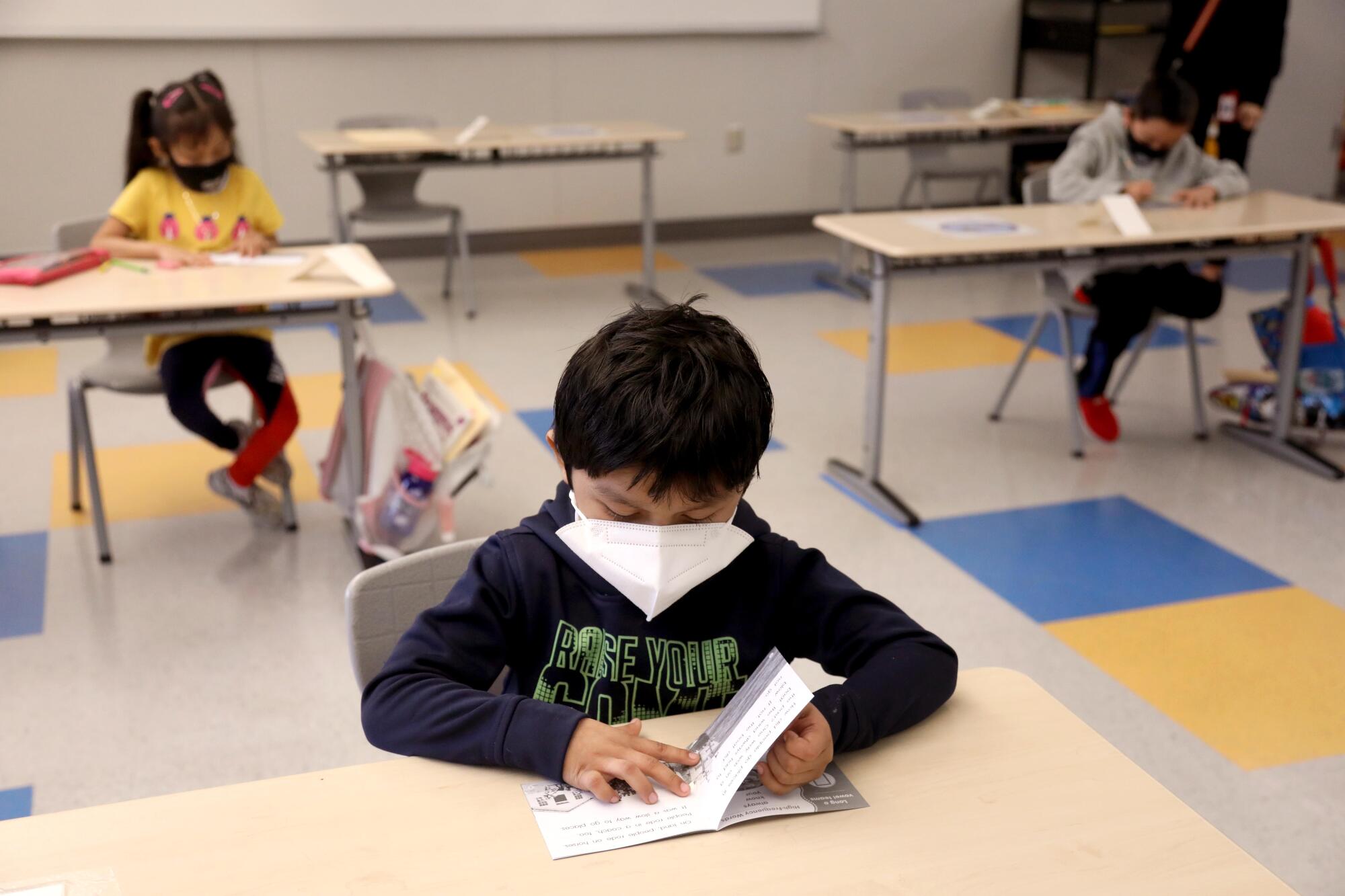 A boy turns the pages of a book.