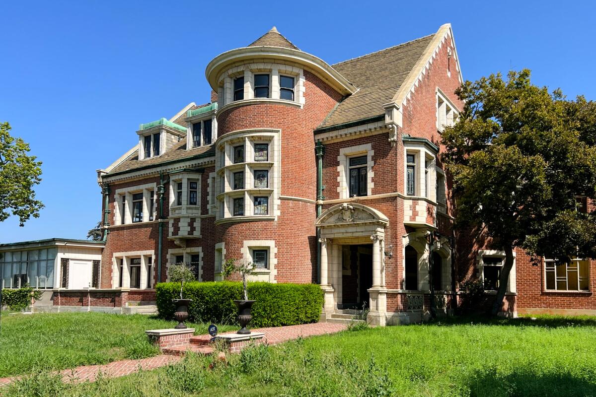 A brick mansion with stained glass windows and turret-like feature