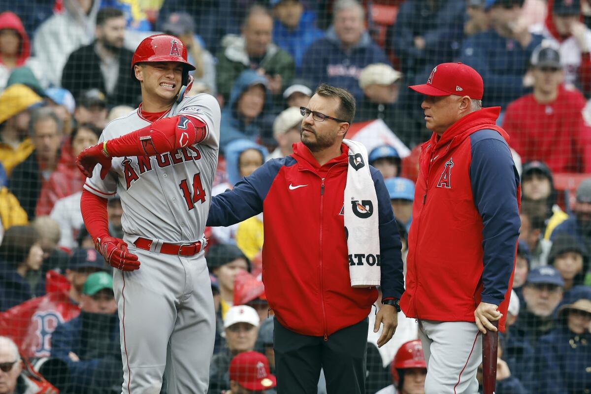 Logan O'Hoppe, left, grimaces as he speaks to a team trainer and manager Phil Nevin.