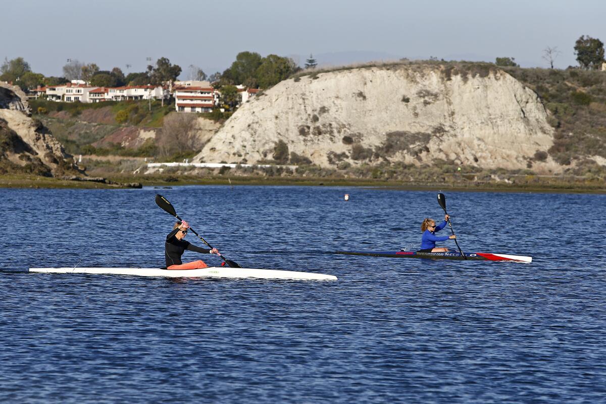 Kayakers paddle through Newport Bay at the Newport Aquatic Center in Newport Beach.