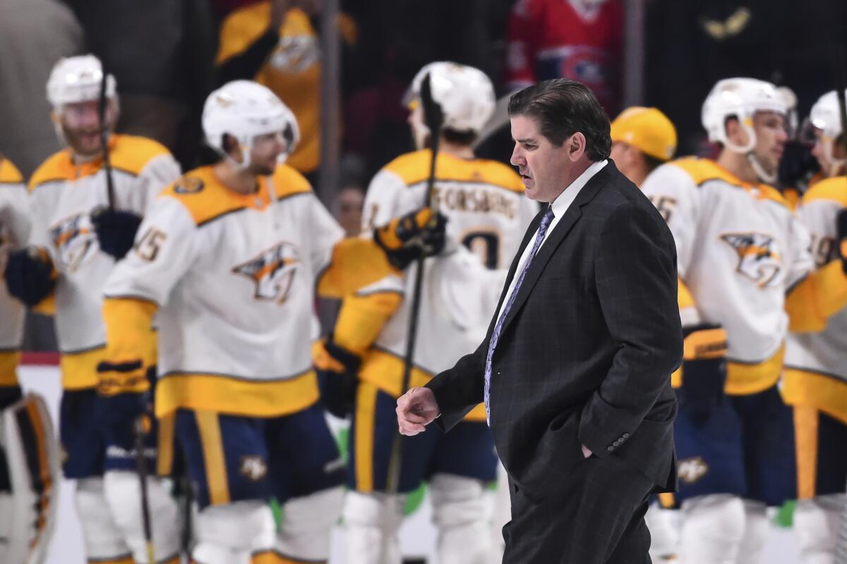 Predators coach Peter Laviolette walks past his team as they celebrate a victory over the Canadiens on Feb. 10, 2018.