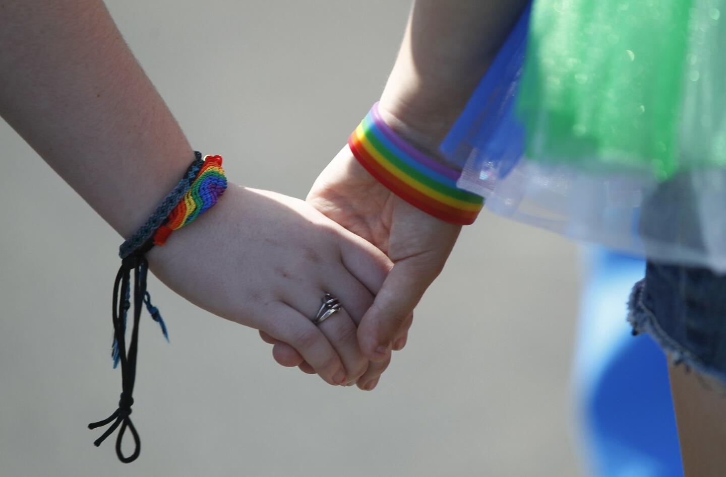 Roxy Fernstrom, right, and Megan Kelly hold hands while at the seventh annual Pride By the Beach event in Oceanside on Saturday, October 11, 2014.