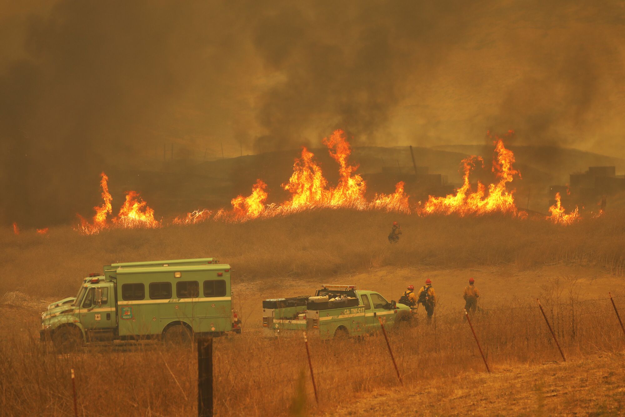 Firefighters watch grass burn