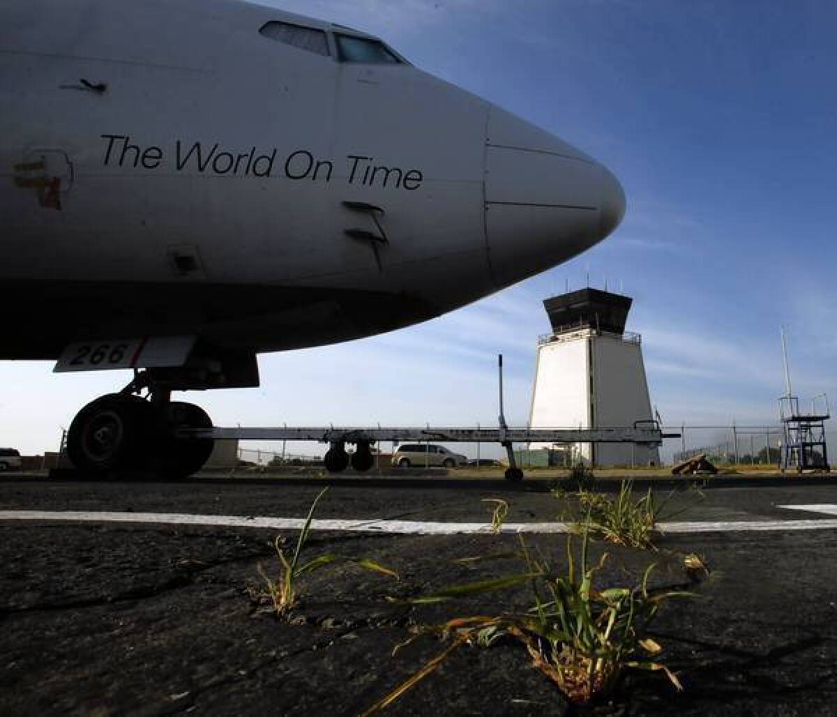 A FedEx plane is parked in front of Riverside Municipal Airport's air-traffic control tower, which is among those set to close next month.