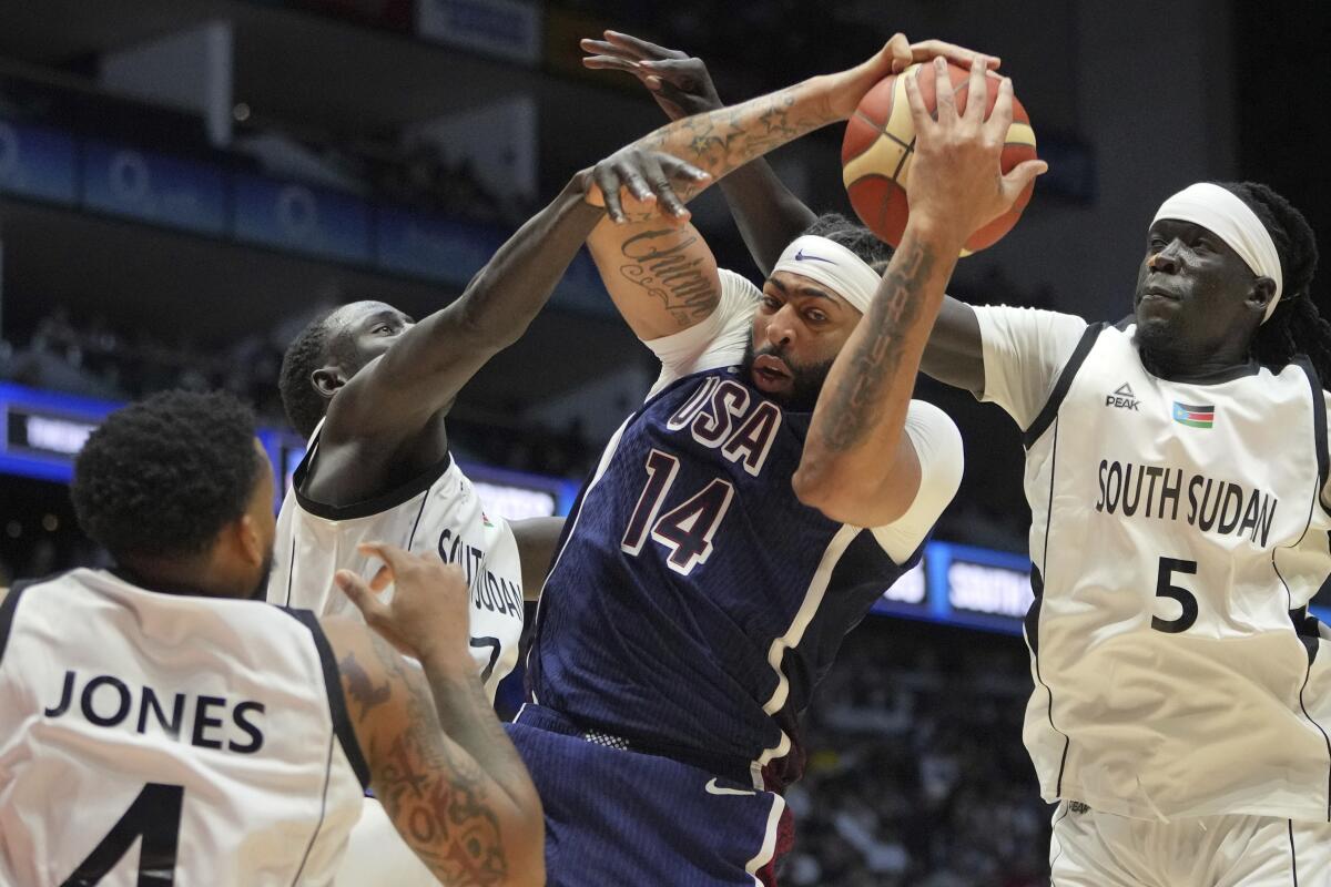 U.S. forward Anthony Davis, center, attempts to score against South Sudan's Nuni Omot, right, and Khaman Maluach.