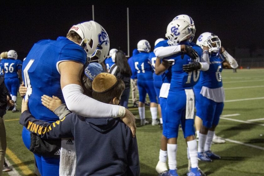 Culver City quarterback Zevi Eckhaus consoles his brothers Yanki and Chaim after his final high school game.