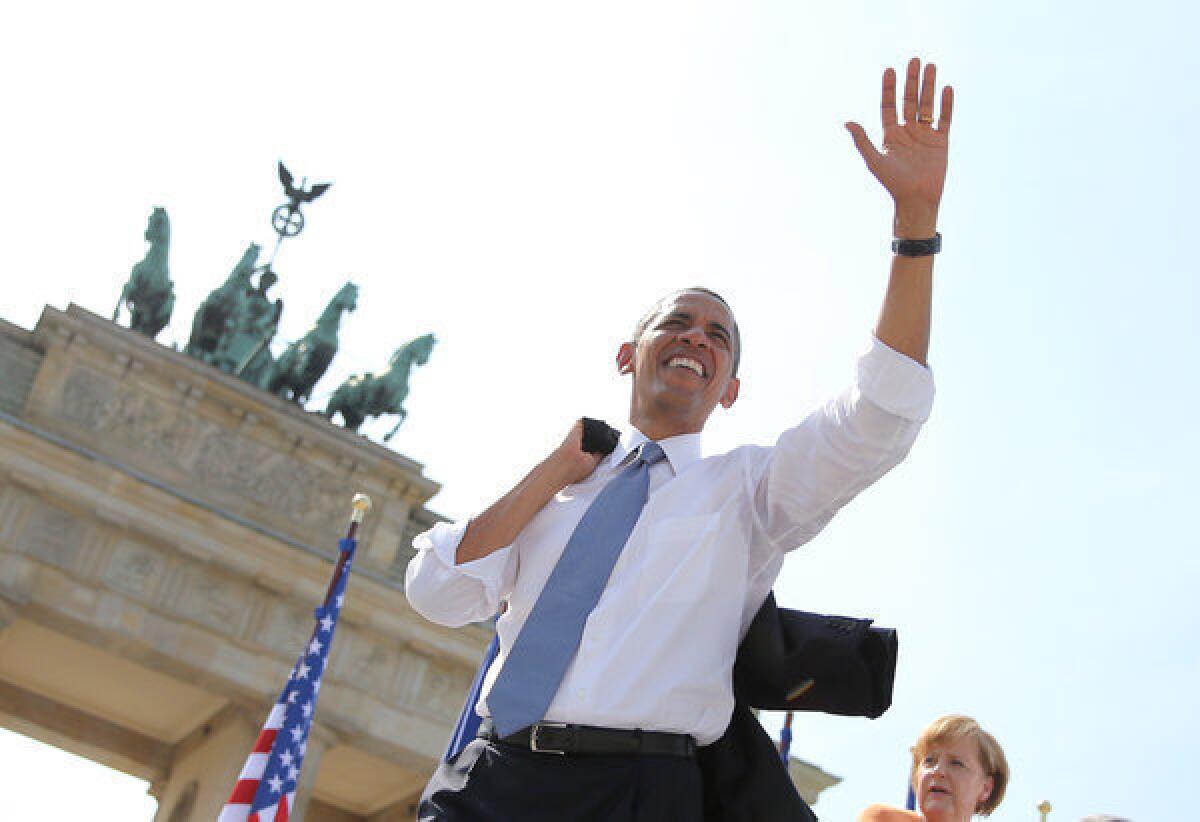 President Obama waves to spectators before he delivers a speech in front of the Brandenburg Gate in Berlin.