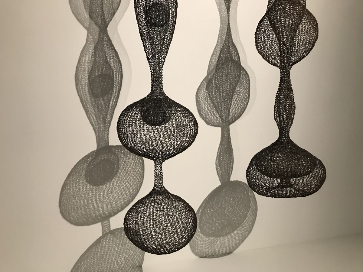 A detail of two Asawa sculptures reveals bulbous and spherical forms made of woven wire.