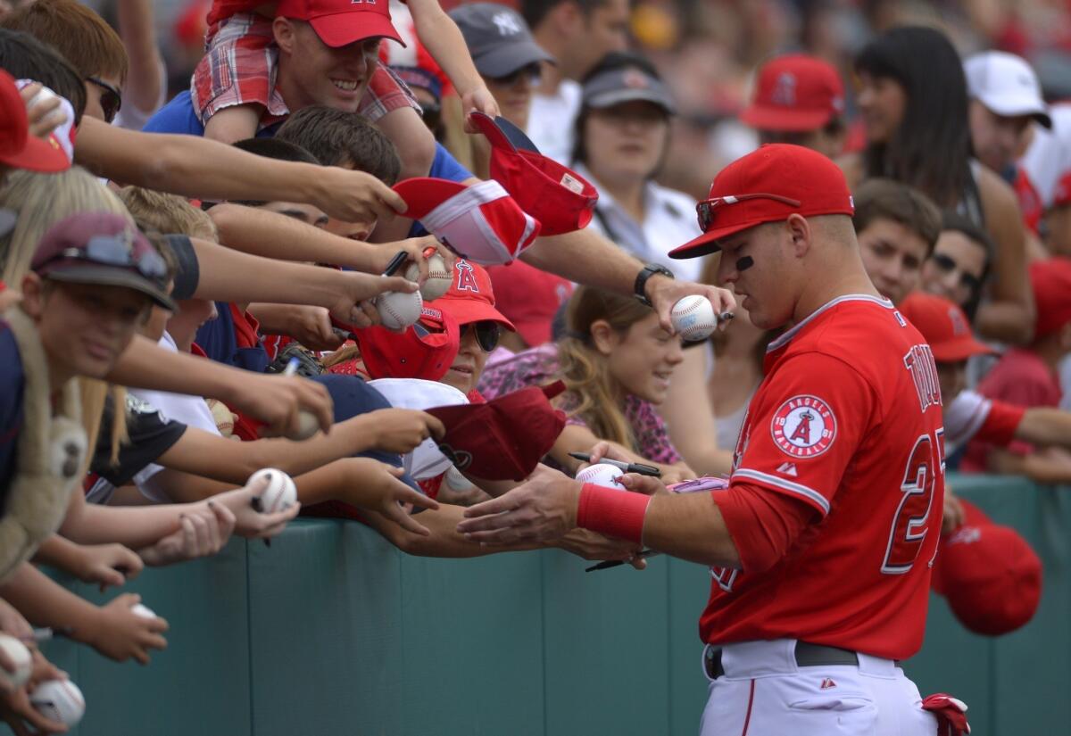 Angels outfielder Mike Trout signs autographs prior to Sunday's game against the Houston Astros.