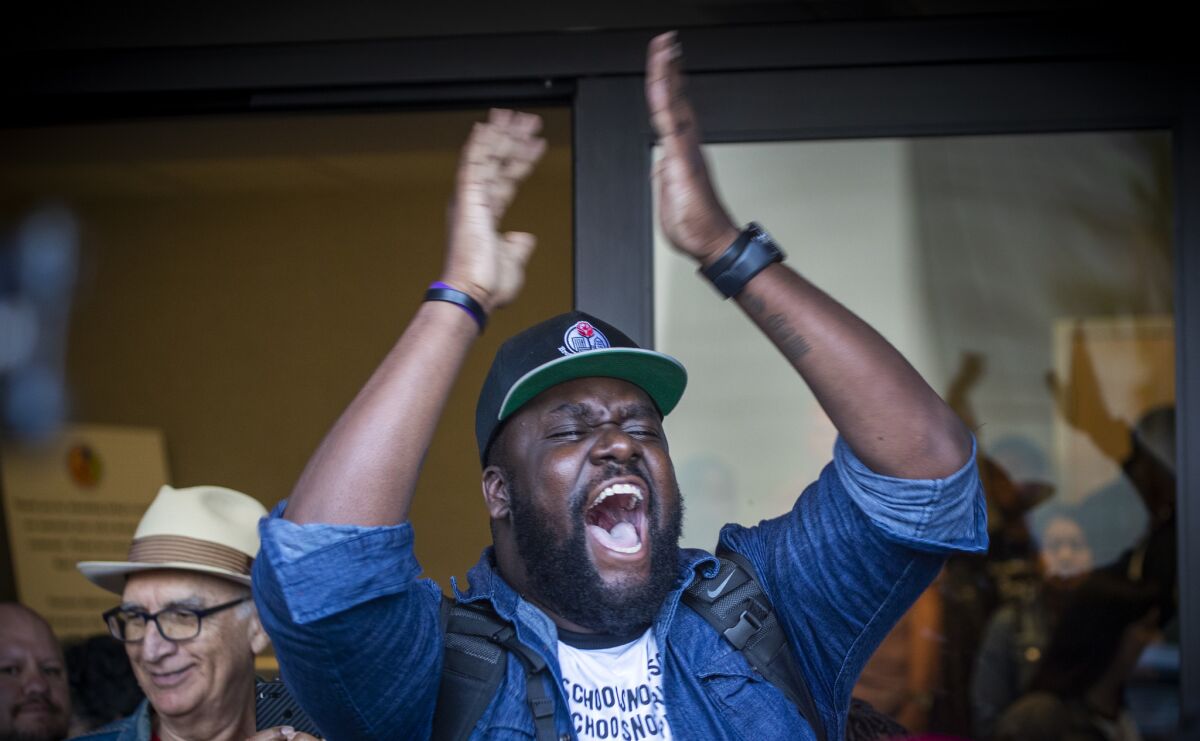 David Turner, center, of Brothers, Sons, Selves LA celebrates after the L.A. school board voted to end the controversial policy of interrupting classes to randomly search students.