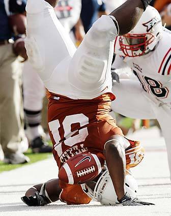 Texas running back Cody Johnson is upended as he goes out of bounds after an 18-yard gain against Florida Atlantic during the second quarter of an NCAA football game on Saturday in Austin, Texas.