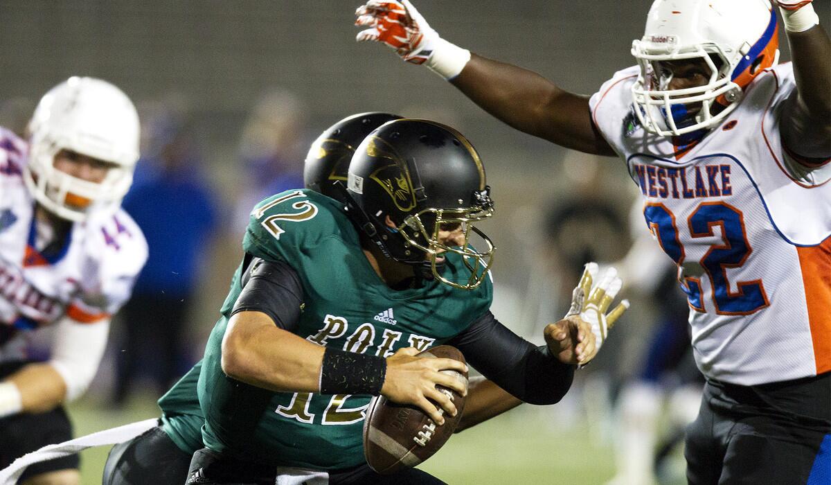 Long Beach Poly quarterback Josh Love can't avoid a sack by Westlake linebacker Quincy Bennett in the first half Friday night at Veterans Stadium.