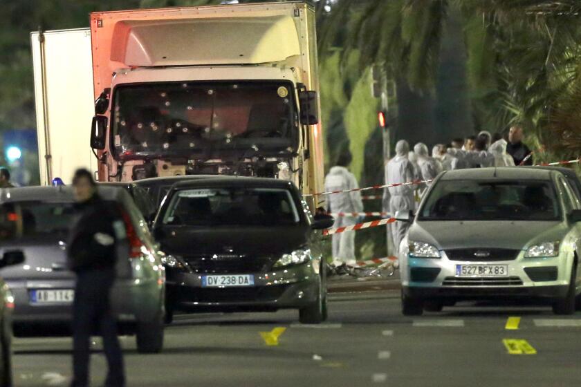 Forensic officers stand near the truck that plowed July 15 through a crowd in Nice, southern France.