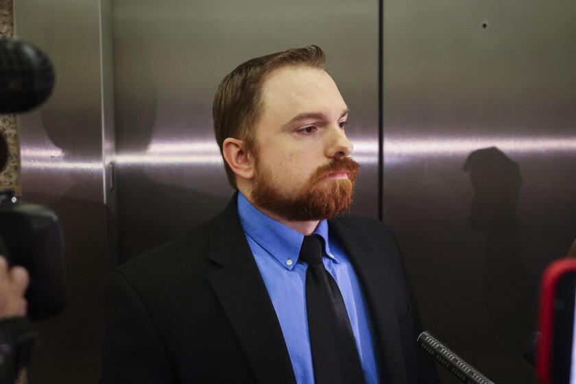 FILE- Former Fort Worth police officer Aaron Dean waits by the elevators after a hearing in his case on Tuesday, Nov. 16, 2021. A judge on Wednesday, Dec. 15, delayed the murder trial of the former police officer in Texas charged with fatally shooting a Black woman through a back window of her home in 2019. Judge David Hagerman tentatively rescheduled the trial for May 9, the Fort Worth Star-Telegram reported. (Yffy Yossifor/Star-Telegram via AP, File)