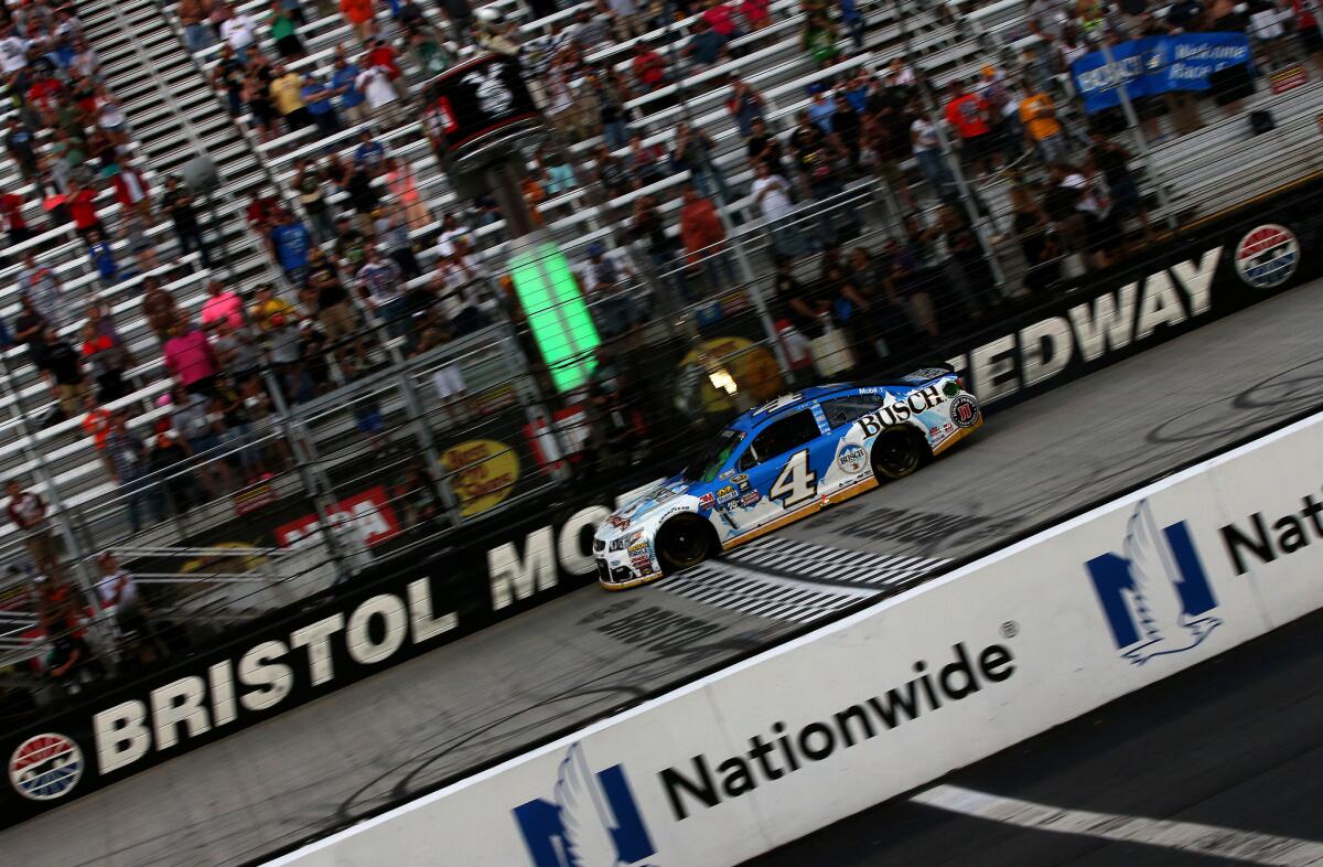 Kevin Harvick, driver of the Busch Beer Chevrolet, takes the checkered flag to win the Bass Pro Shops NRA night race at Bristol Motor Speedway on Aug. 21.