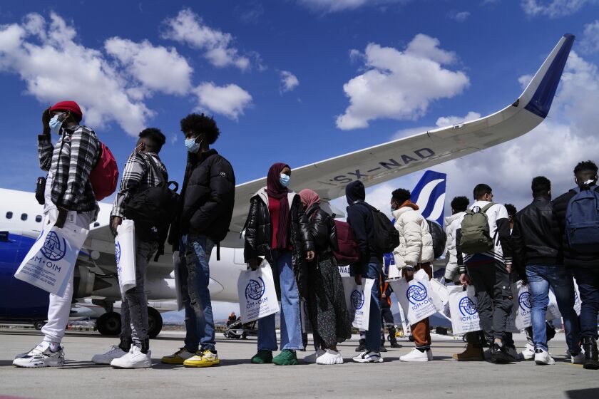 A group of unaccompanied minors wait in a queue to board a plane bound for Lisbon, Portugal, at the Eleftherios Venizelos International Airport in Athens, Greece, March 28, 2023. The 15 children from Somalia, Gambia and Pakistan were being transferred as part of a voluntary relocation programme among European Union member states. (AP Photo/Thanassis Stavrakis)