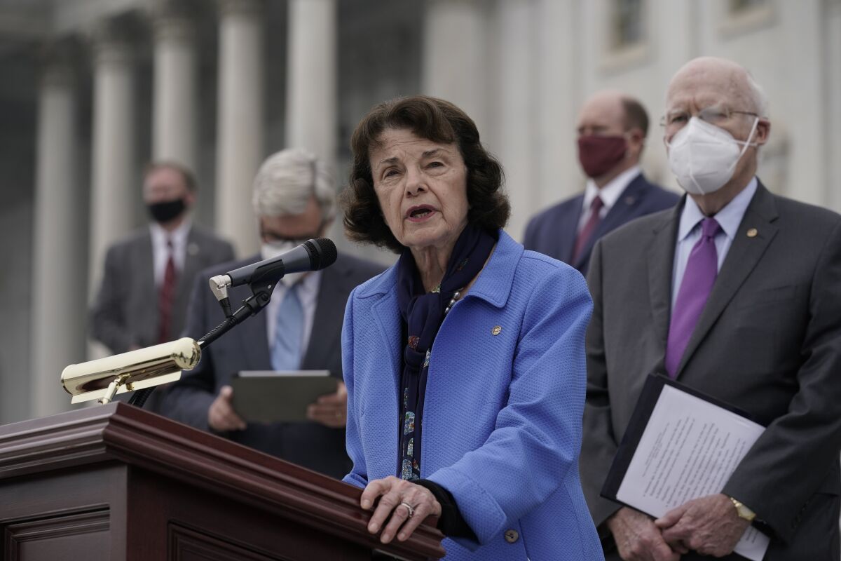 Senator Dianne Feinstein speaks into a microphone at a lectern in front of the Capitol building