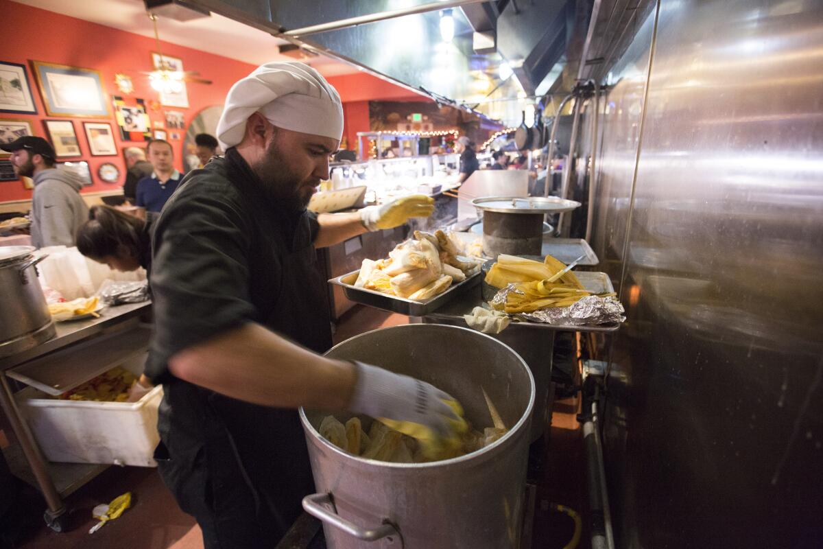 A worker stuffs a tin with tamales at Tlaquepaque Restaurant in Placentia. 