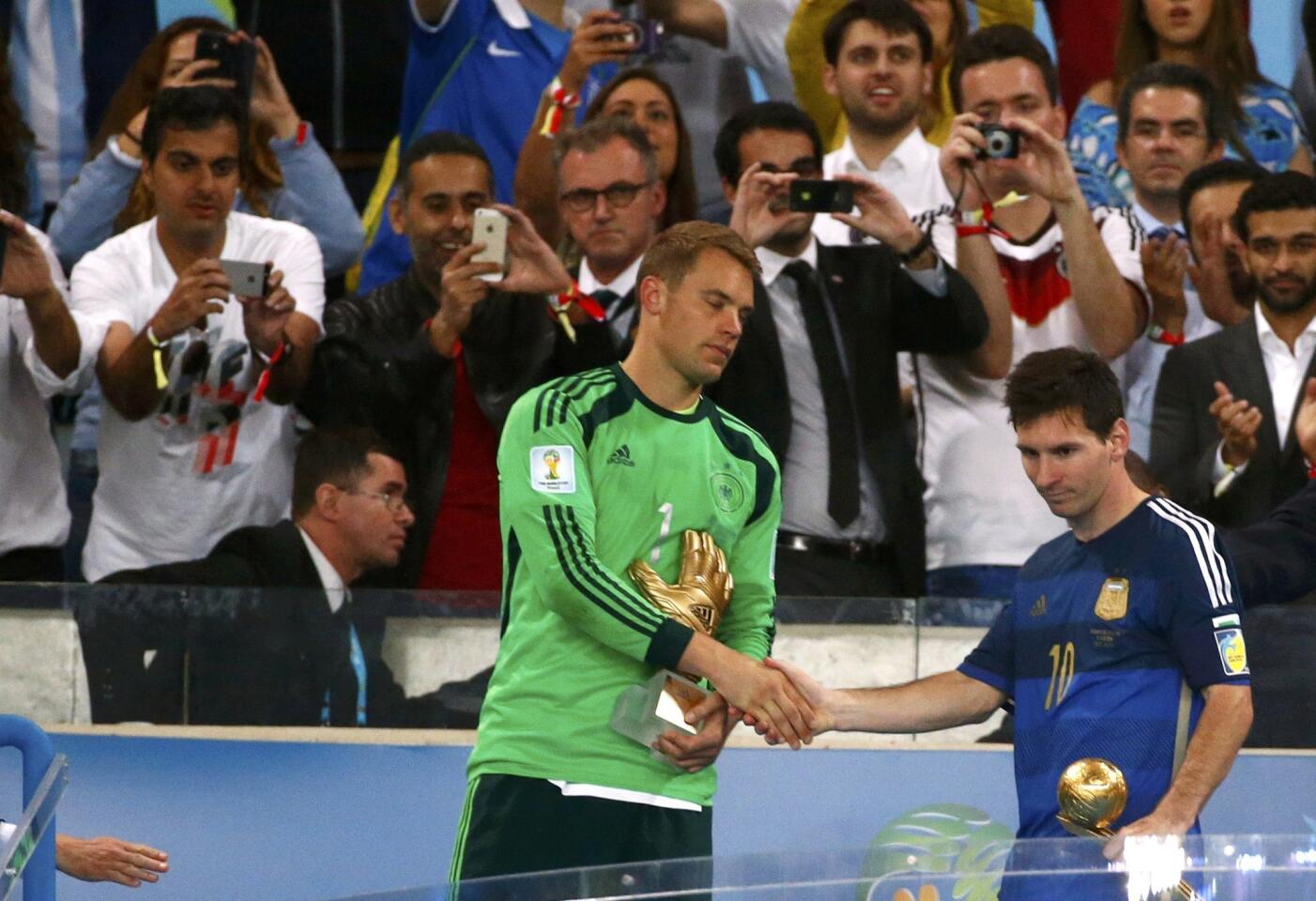 Germany's goalkeeper Manuel Neuer and Argentina's Lionel Messi shake hands after receiving awards after their 2014 World Cup final at the Maracana stadium
