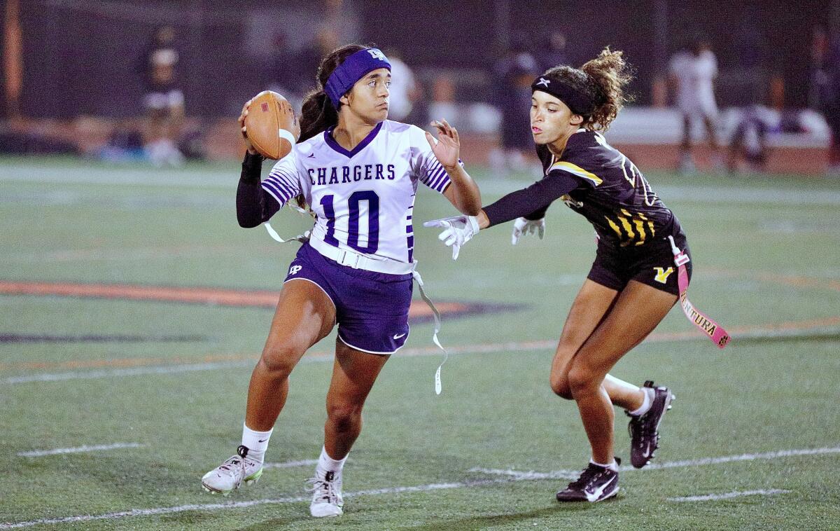 Dos Pueblos High quarterback Liliana Rodriguez looks to throw a pass while evading a Ventura defender.