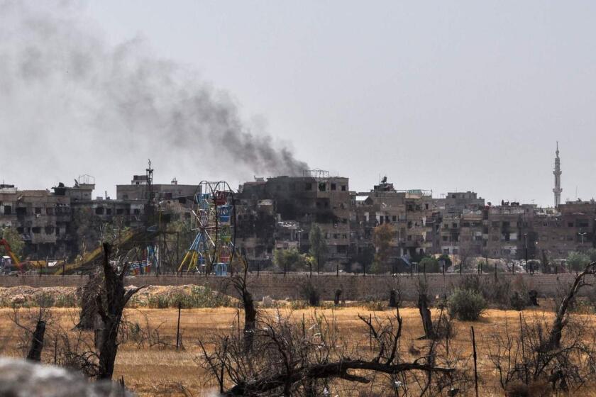 A picture taken during a Syrian army-organised tour on April 20, 2018 shows a view of the Eastern Ghouta town of Douma on the outskirts of the capital Damascus, with a smoke plume rising in the background. / AFP PHOTO / STRINGERSTRINGER/AFP/Getty Images ** OUTS - ELSENT, FPG, CM - OUTS * NM, PH, VA if sourced by CT, LA or MoD **