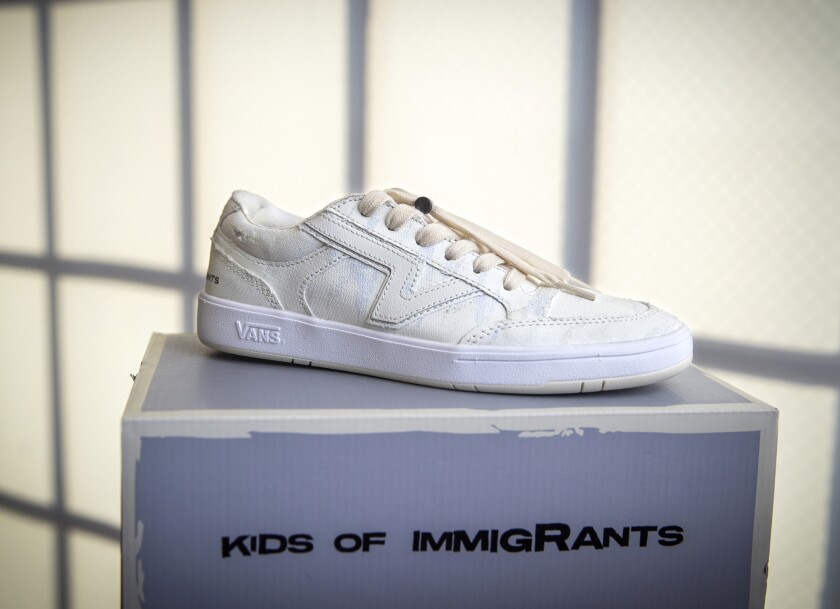 A white sneaker sitting on a shoe box.