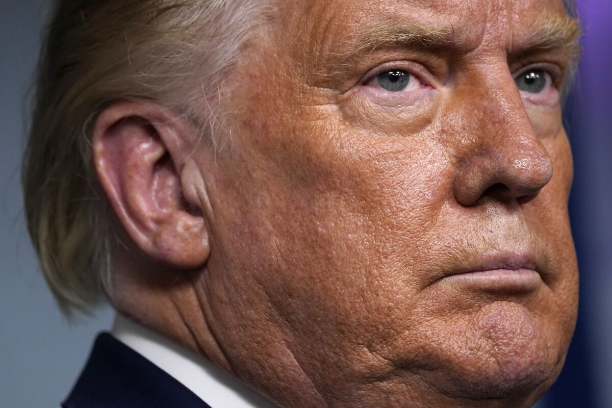 President Trump listens during a news conference at the White House on Friday.