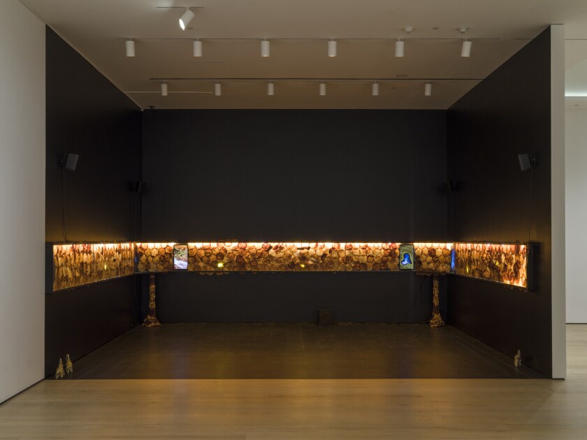 In a darkened room, an illuminated band features repeating circular patterns.
