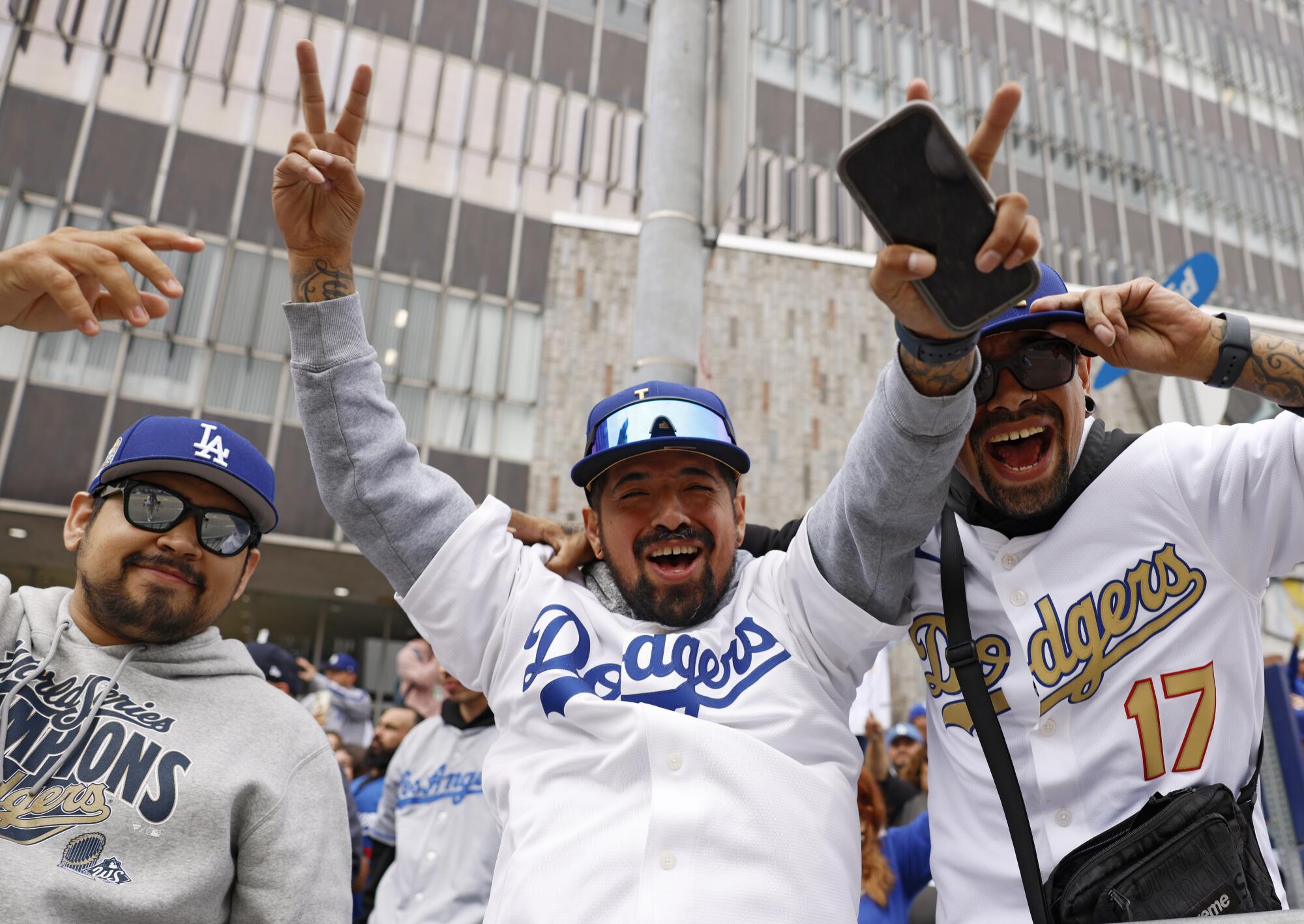 Pictures: World Sequence Champion Dodgers parade by Downtown LA 2 From left, Mike Soto, Luis Espino, and Francisco Espino, join fans lining the streets of downtown Los Angeles.