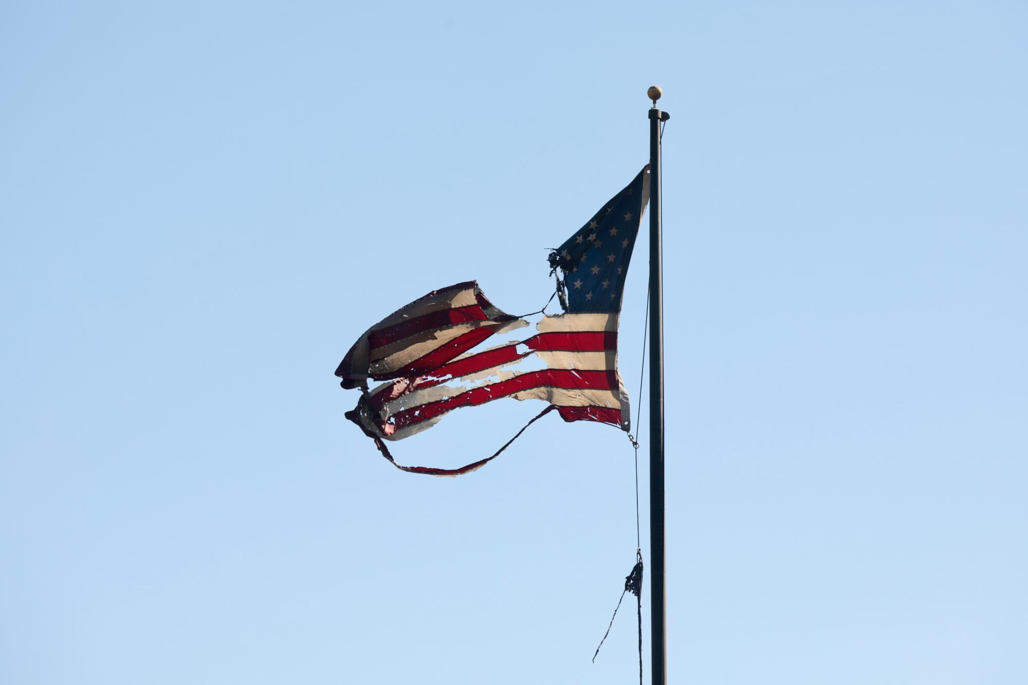 A tattered American flag flutters in the wind