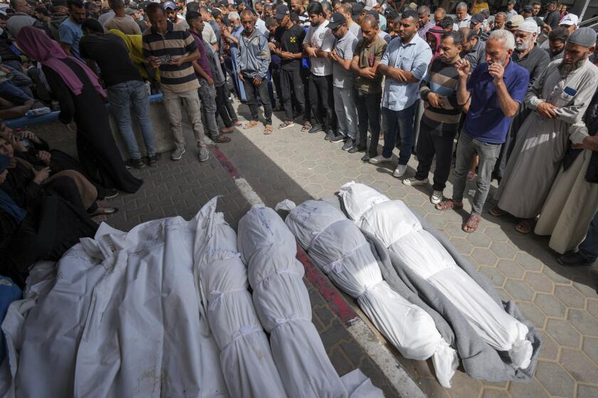 Mourners pray over the bodies of Palestinians who were killed in an Israeli airstrike in Nuseirat, at the Al Aqsa hospital in Deir al Balah, Gaza Strip, Sunday, May 19, 2024. (AP Photo/Abdel Kareem Hana)