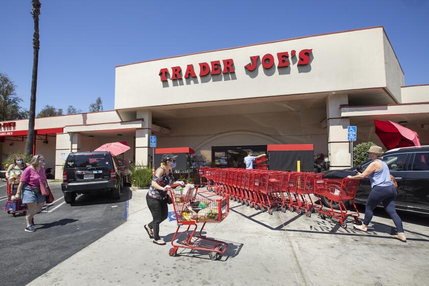 SHERMAN OAKS, CA -JULY 20, 2020: Customers make their way with shopping carts outside of Trader Joe's on Riverside Dr. In Sherman Oaks. Trader Joe's has responded to criticisms about its packaging by announcing that it is in the process of eliminating labels that use ethnic-sounding names intended to be humorous. The offending products bear such labels as Trader Ming's for foods and condiments related to Chinese cuisine, Trader Jose's for Mexican-style products and Trader Giotto's for Italian-themed items. (Mel Melcon / Los Angeles Times)