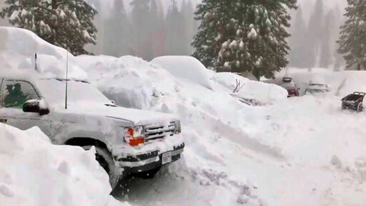 Foto tomada de un video publicado por Joel Keeler muestra vehículos sepultados por la nieve en el estacionamiento del hotel Montecito Sequoia Lodge en la Sierra Nevada de California.