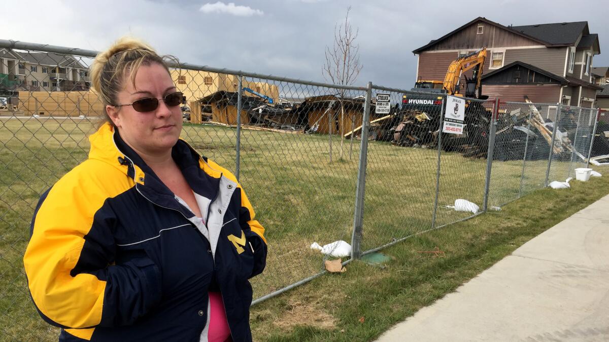 Heather Sawlidi, 31, stands in front of the remains of a home that exploded April 17 in Firestone. She lives a few doors away and says she does not feel safe in her house.