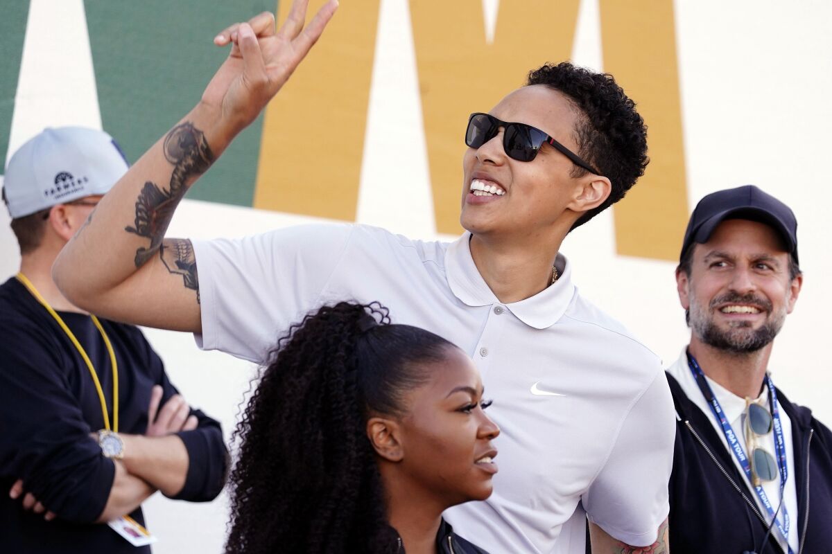 WNBA star Brittney Griner acknowledges fans as she watches on the 16th hole at the Phoenix Open.