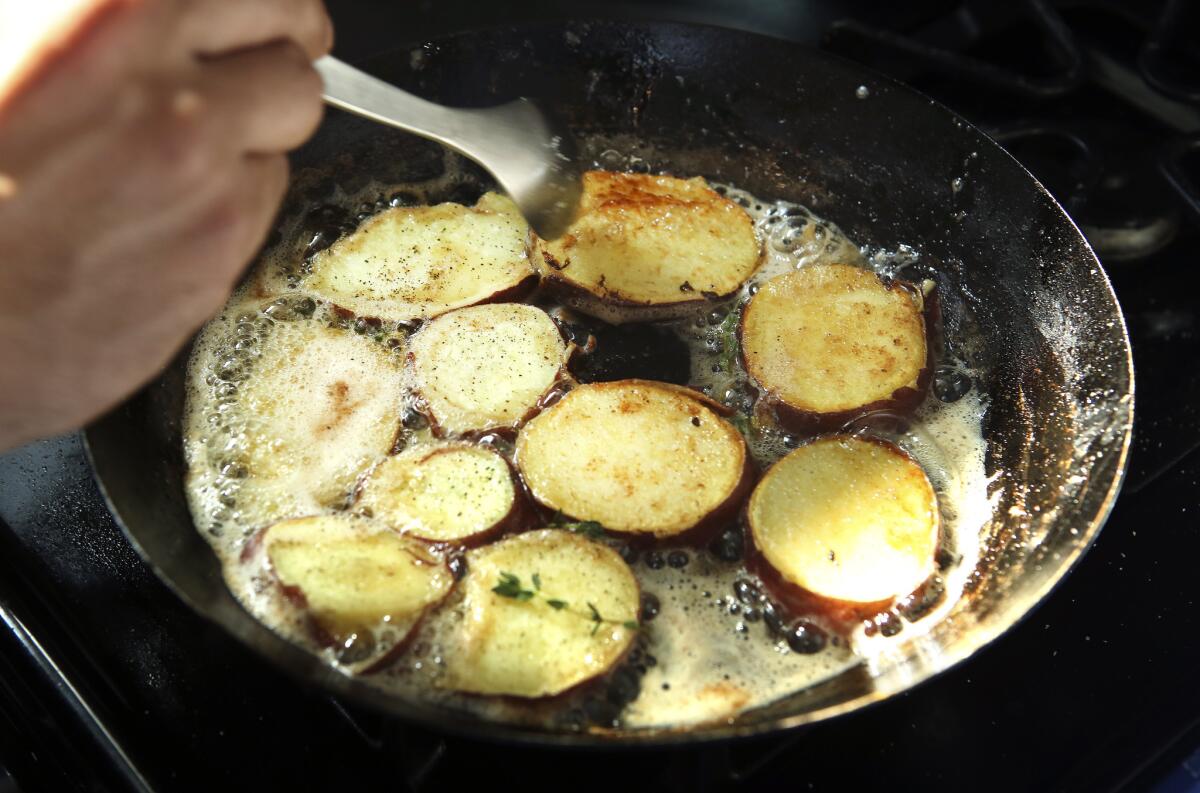 Avila cooks potatoes on the stove top, while making his sweet potato breakfast taco.