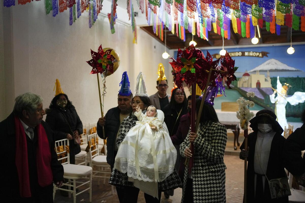Los residentes participan en la procesión de "Niñopa" durante una "posada" navideña