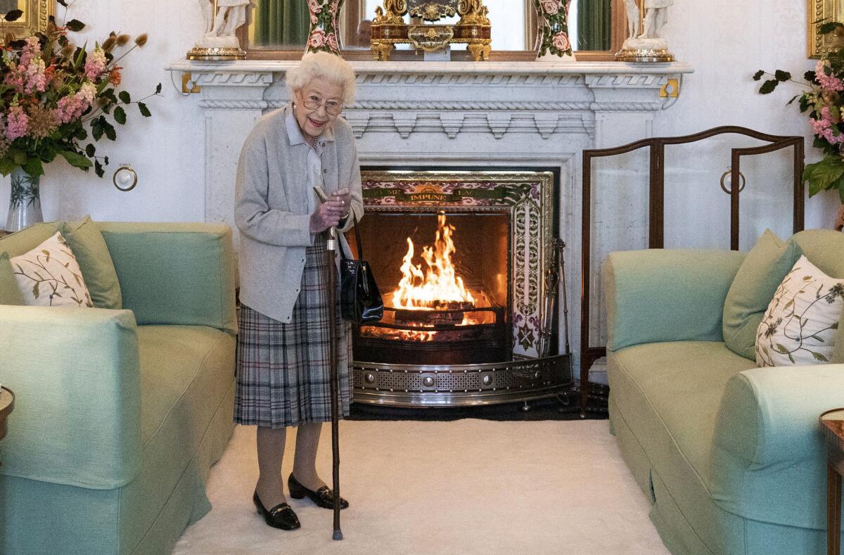 Britain's Queen Elizabeth II before a fireplace