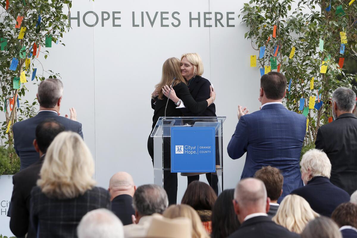 Annette Walker, right, president of City of Hope Orange County, shares a hug with patient Kandace McMenomy during the grand opening Tuesday of City of Hope's outpatient cancer clinic in Newport Beach.