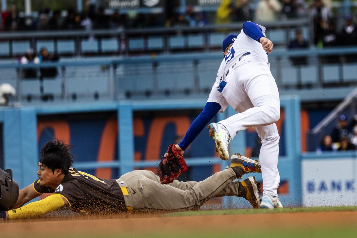 Dodgers second baseman Gavin Lux tags out San Diego's Ha-Seong Kim on a stolen-base attempt.