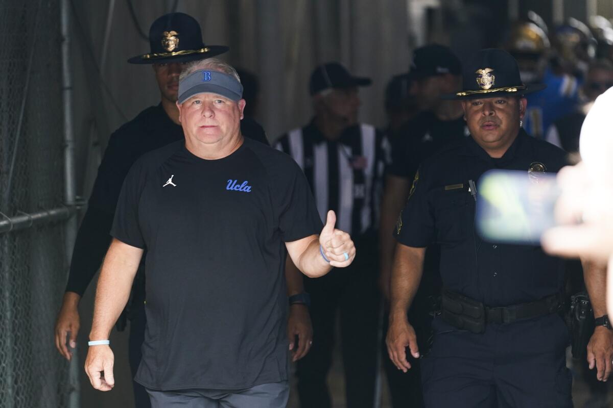 UCLA coach Chip Kelly gives a thumbs up as he enters the Rose Bowl 