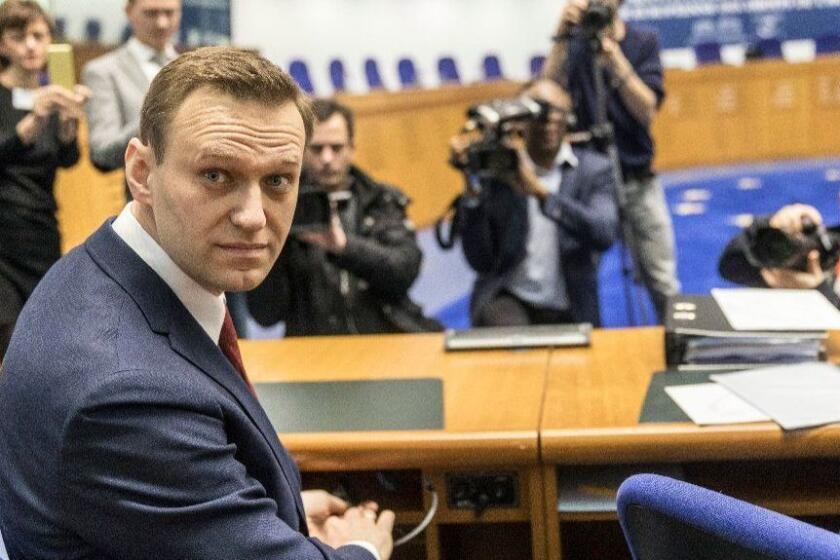 FILE - This is a Wednesday, Jan. 24, 2018. file photo of Russian opposition activist Alexei Navalny as he poses for photographers prior to a hearing at the European Court of Human Rights in Strasbourg, eastern France. Navalny published on Thursday Feb. 8, 2018 an investigation alleging that a Russian Cabinet member received lavish hospitality from billionaire Oleg Deripaska, a tycoon who has been linked to U.S. President Donald Trump's former campaign chairman Paul Manafort. (AP Photo/Jean-Francois Badias/File)