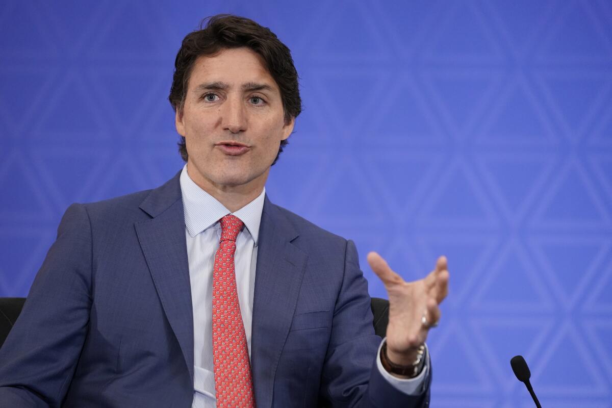 Canadian Prime Minister Justin Trudeau gesturing with his left hand as he speaks at a lectern