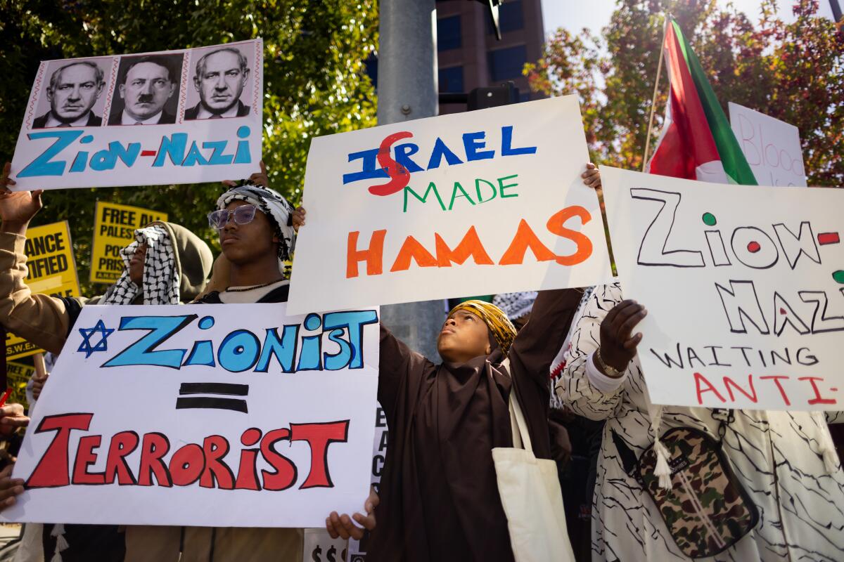 People hold up signs in support of Palestinians.