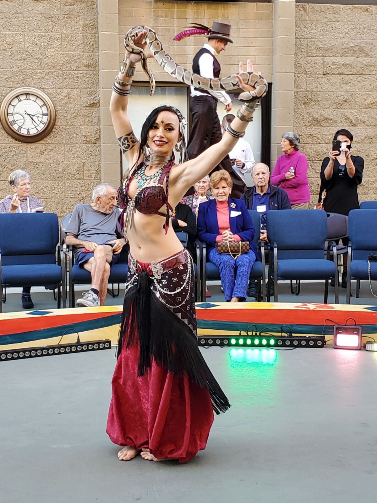 Christina the Snake Charmer dances with a friend as part of Chateau La Jolla's circus-themed open house.