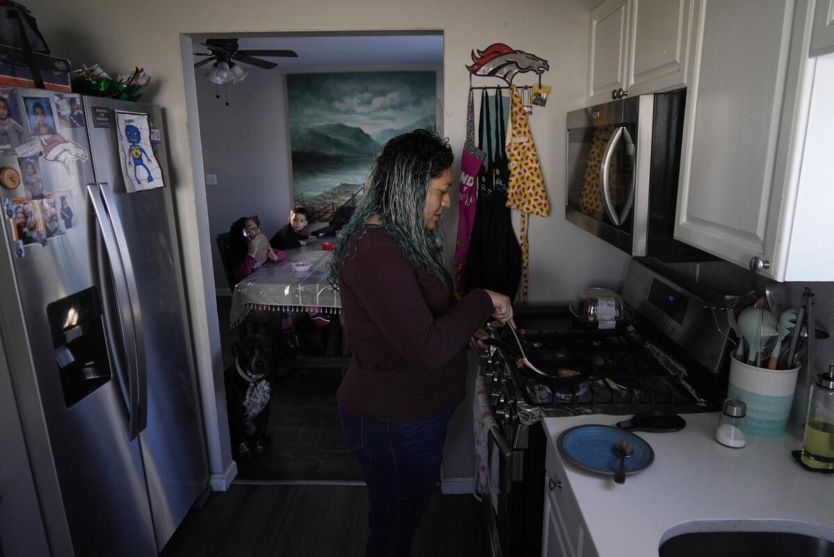 Betty Rivas prepares breakfast for her family Thursday, Feb. 23, 2023, in Commerce City, Colo. 