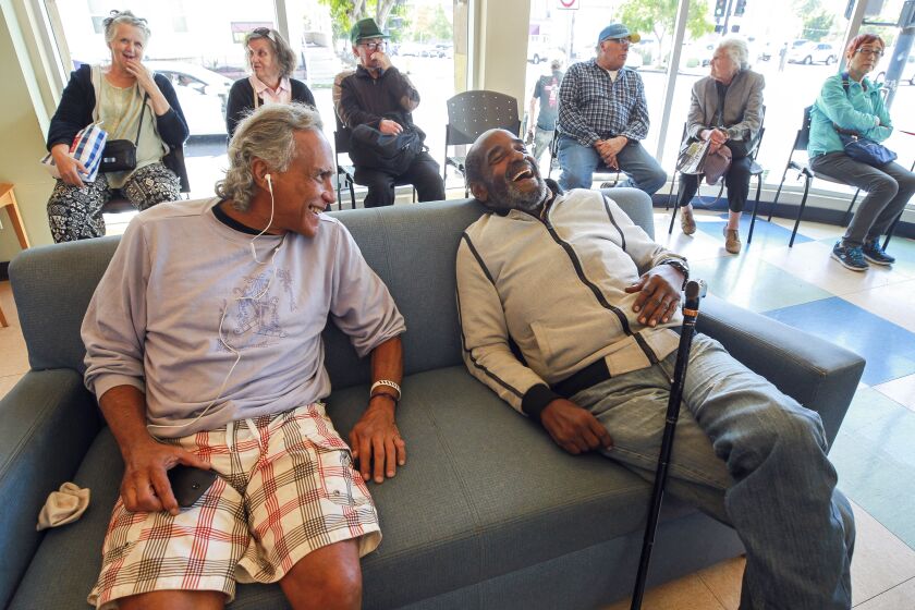 Carl Russell, 72, right, shares a laugh with Victor Quslan, 62, who are both homeless, as they relax in the community room at the Gary and Mary West Senior Wellness Center on Tuesday, October 15, 2019 in San Diego, California.
