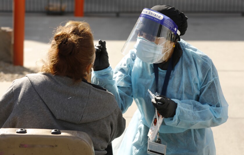 A nurse uses a nasal swab to conduct a coronavirus test