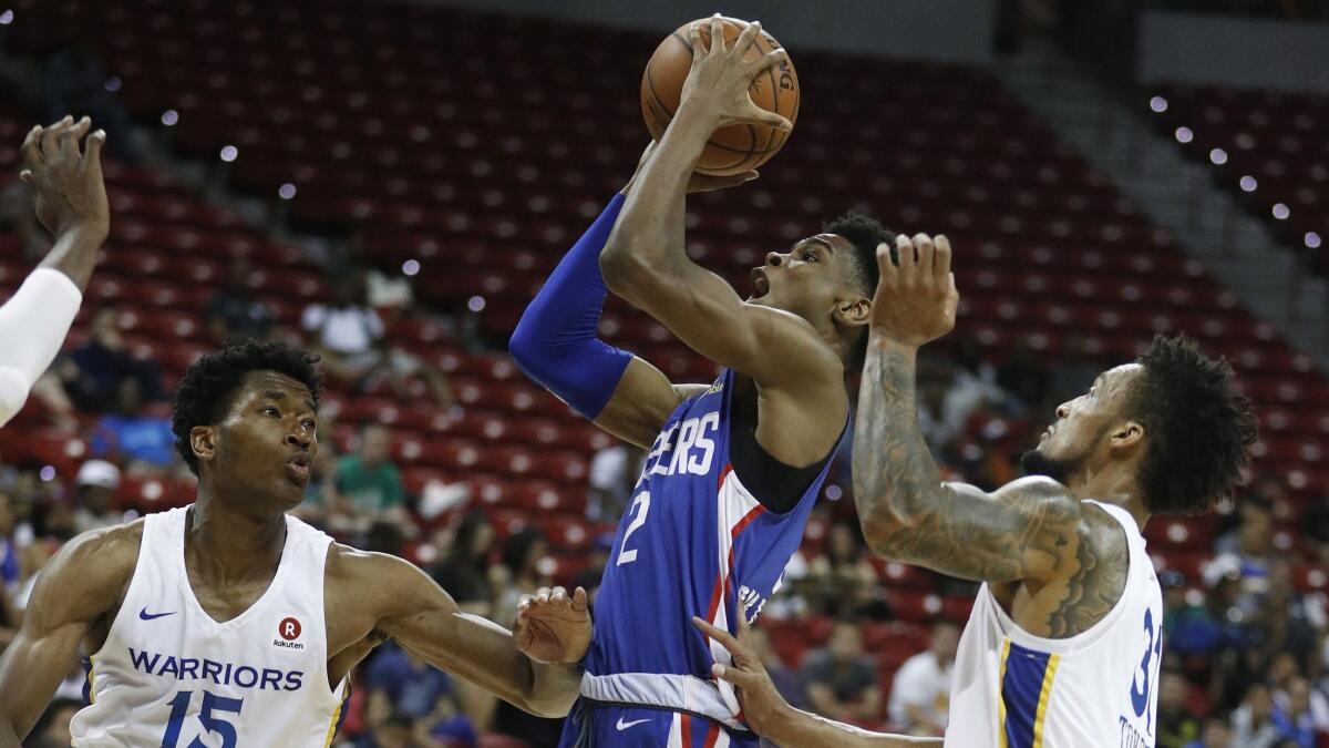Clippers rookie Shai Gilgeous-Alexander powers his way to the basket against Golden State's Damian Jones, left, and J.P. Tokoto during their summer league game Friday night.