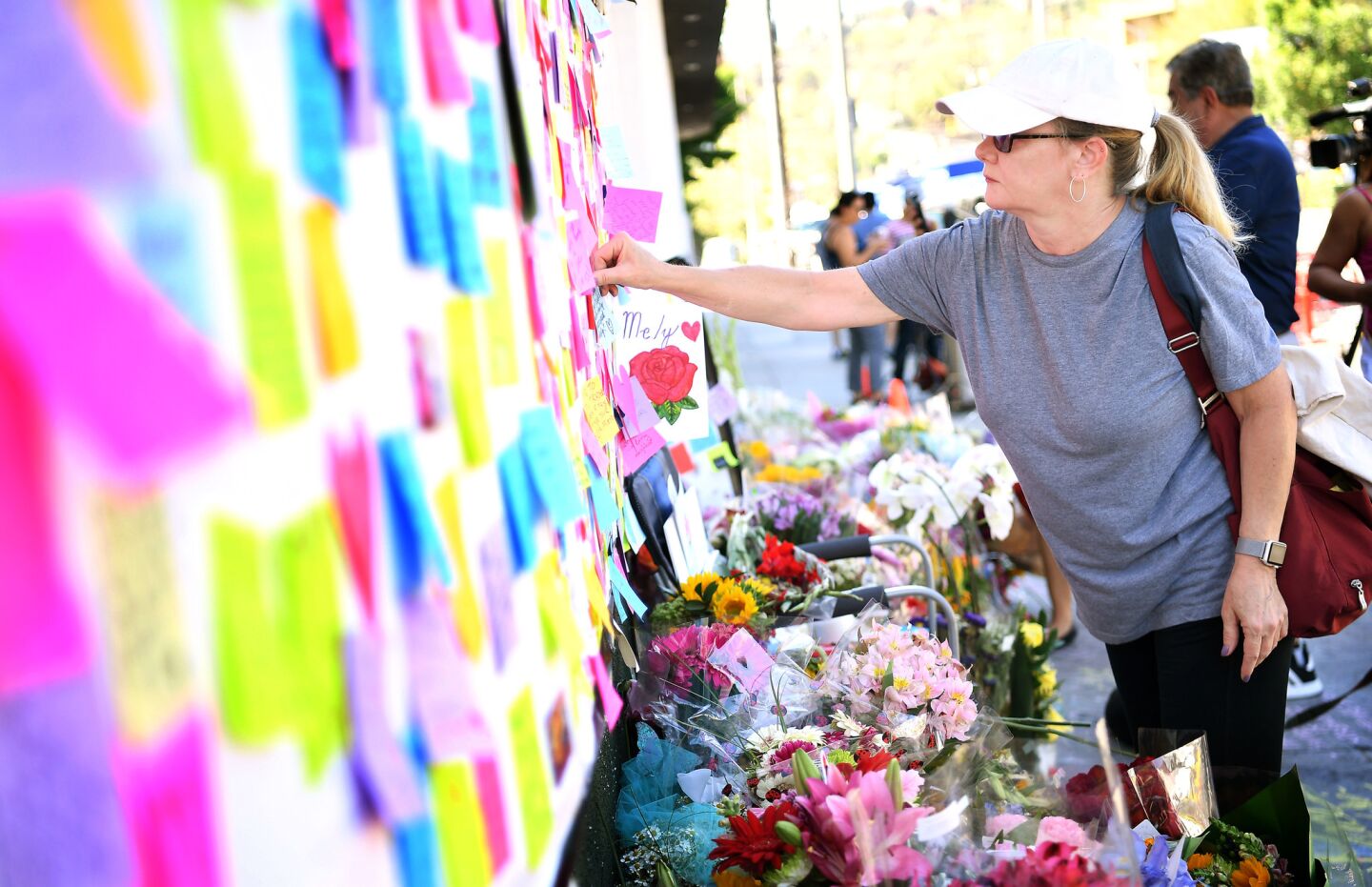 Fiona Shields, of Los Feliz, leaves a note at a memorial outside of Trader Joe's in Silver Lake on Monday.